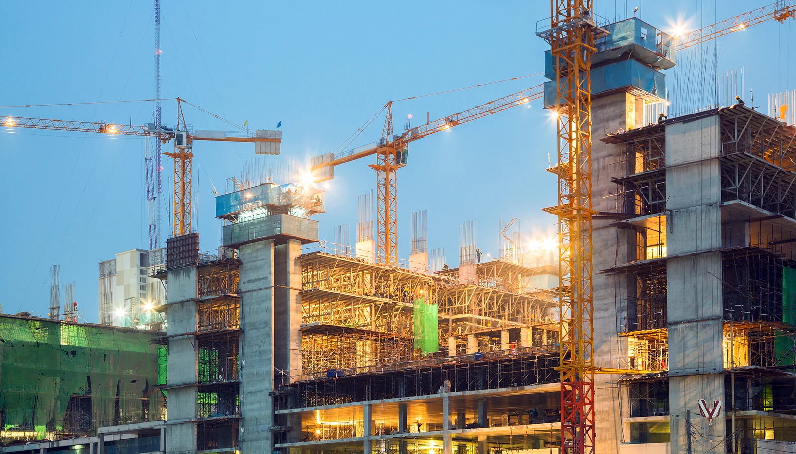 Building construction site with cranes and concrete structure